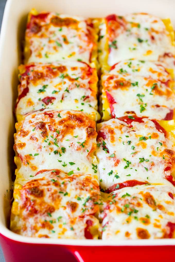 Baked lasagna roll ups topped with melted mozzarella cheese.