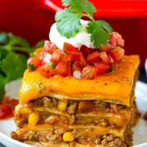 A slice of Mexican lasagna made with layers of cheese, tortillas and meat.