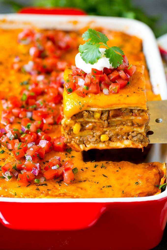 A spatula serving up a portion of Mexican lasagna.