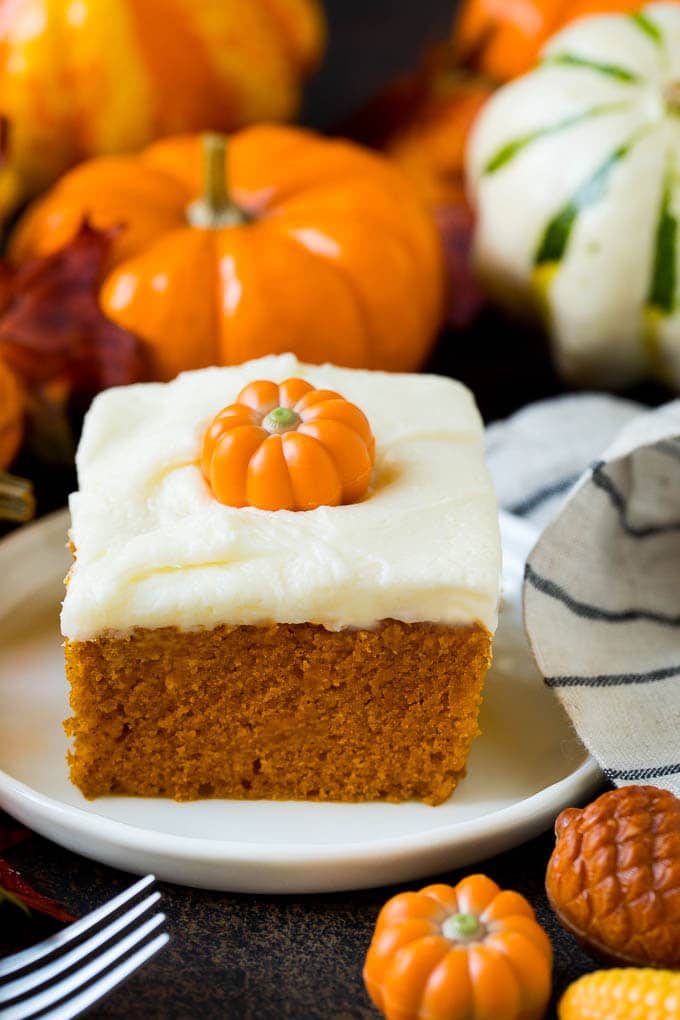 A slice of pumpkin cake topped with cream cheese frosting.