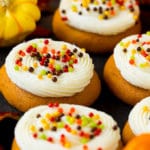 Pumpkin cookies topped with cream cheese frosting and fall sprinkles.