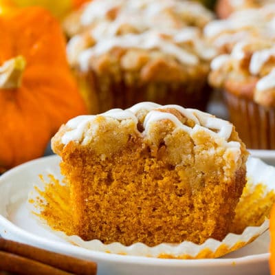 Pumpkin muffins topped with brown sugar streusel and vanilla glaze.