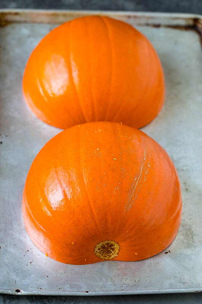 Pumpkin halves on a sheet pan.