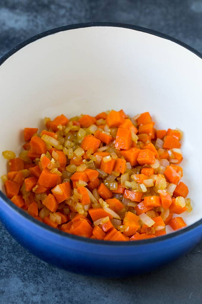 Carrots, onions and garlic cooked in a pot.