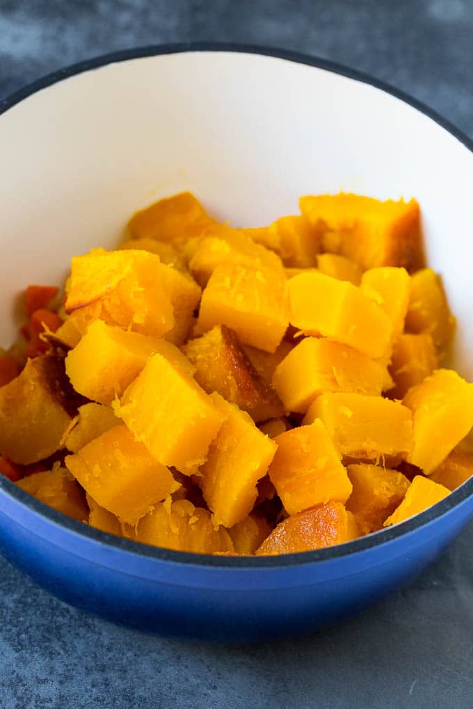 Cubed roasted squash in a soup pot.