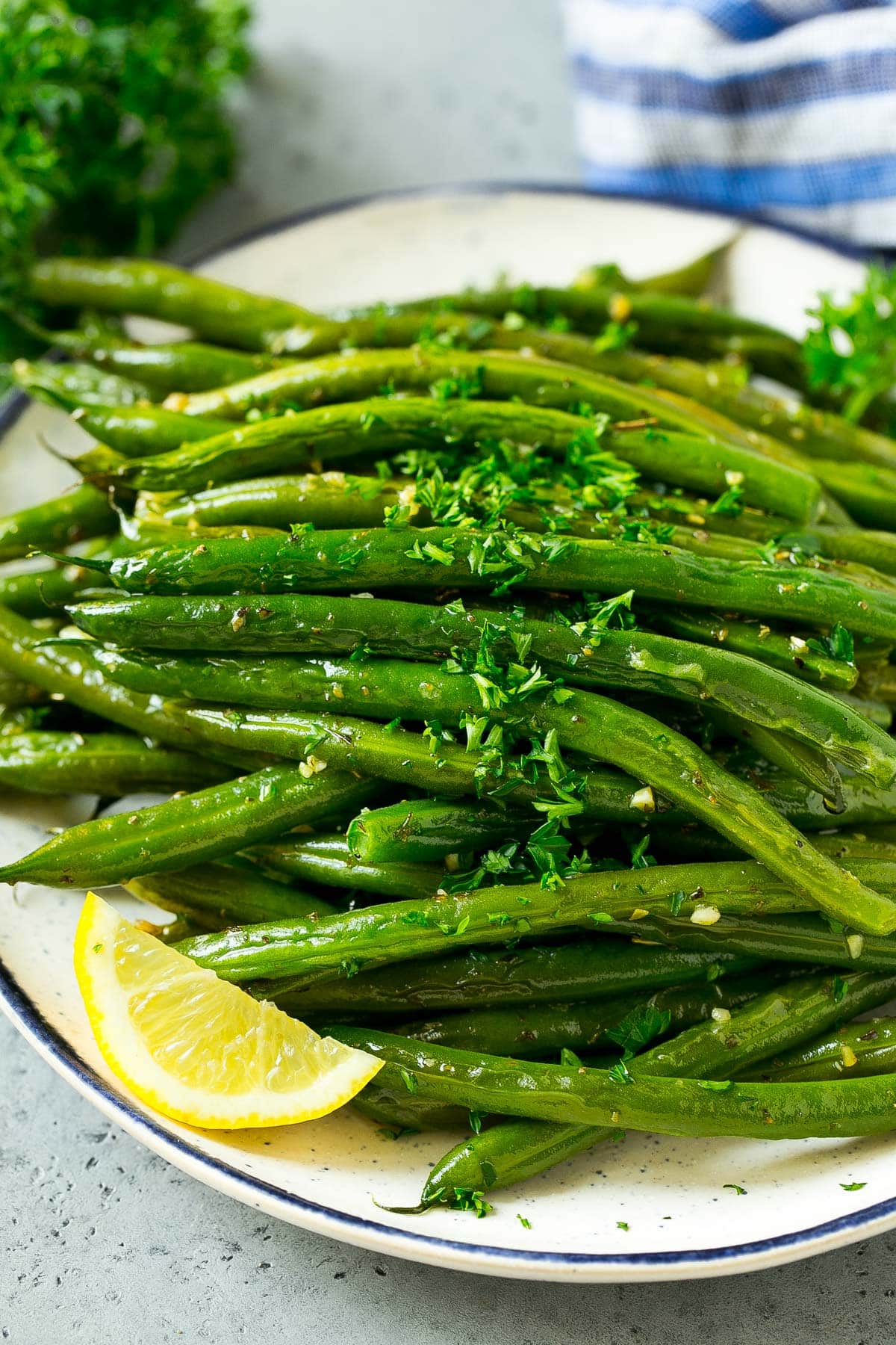 A serving plate of roasted green beans with parsley.