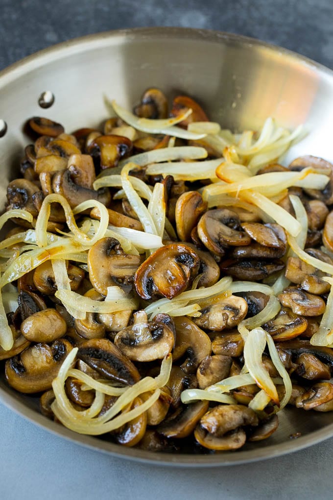 Sauteed mushrooms and onions in a skillet.