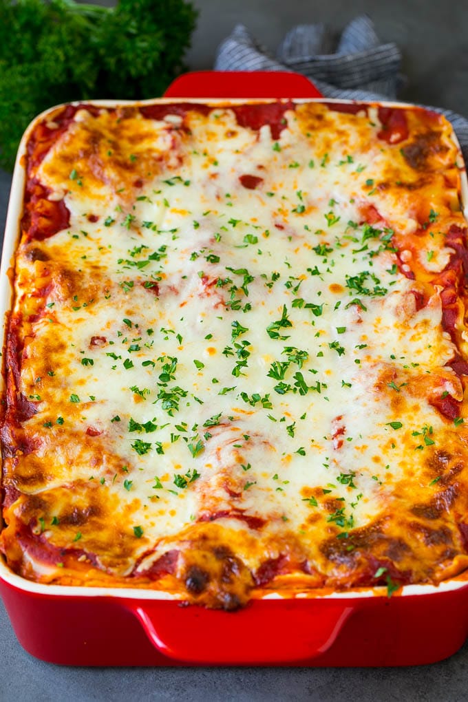 A baked vegetarian lasagna with mozzarella cheese and parsley on top.