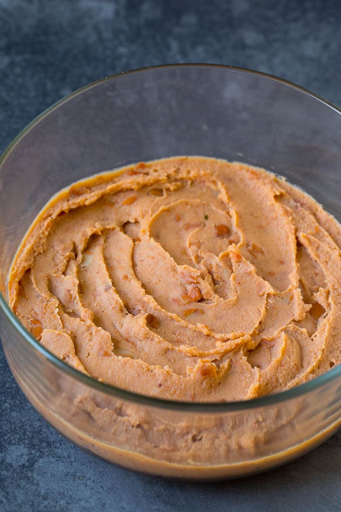 Refried beans spread in a serving bowl.
