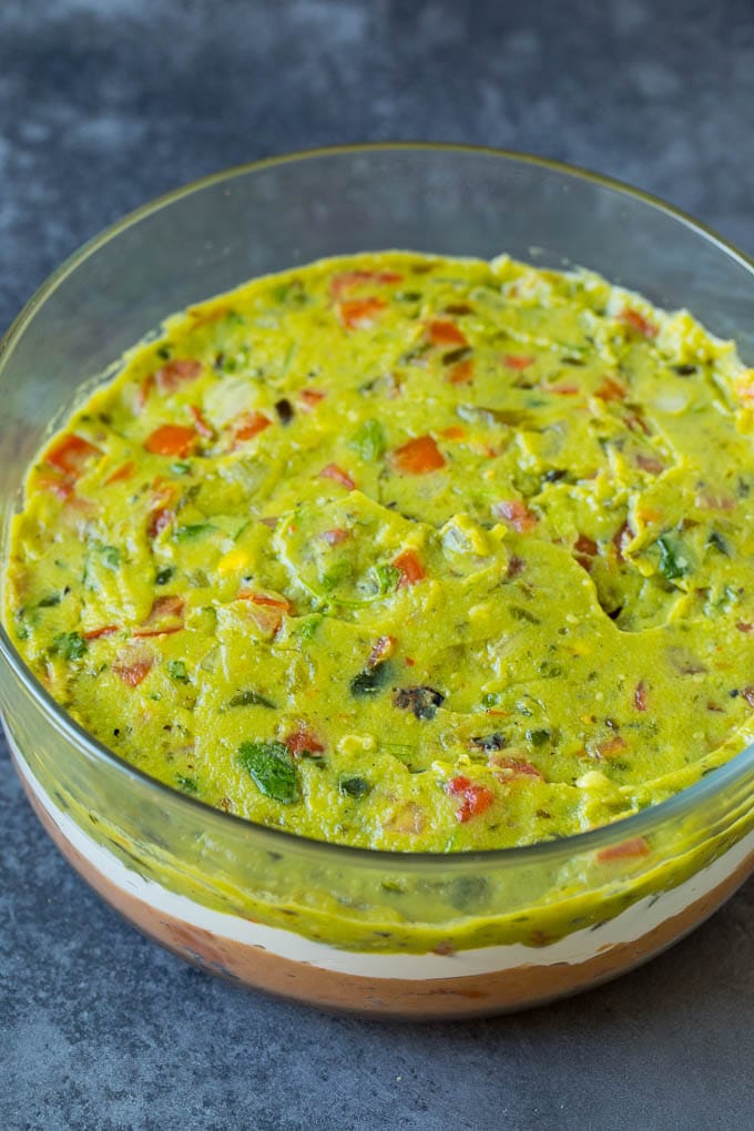 Beans, sour cream and guacamole layered in a bowl.