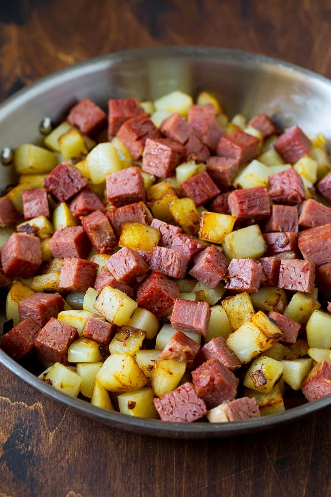 Corned beef and potatoes cooked together in a pan.