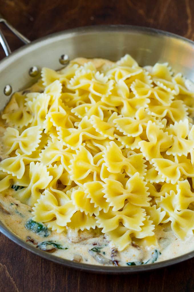 Pasta in a pan of cream sauce.