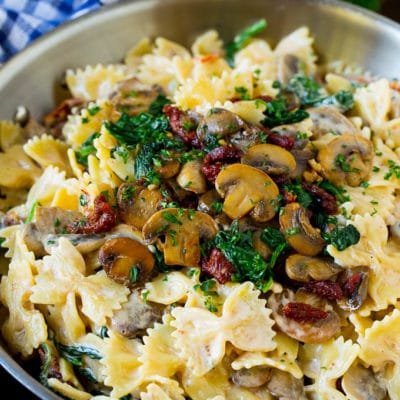 Farfalle pasta with spinach and mushrooms in a creamy sauce.