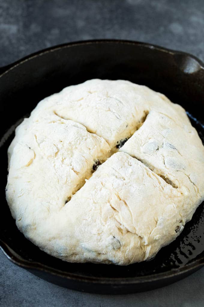 A shaped loaf of soda bread in a skillet.