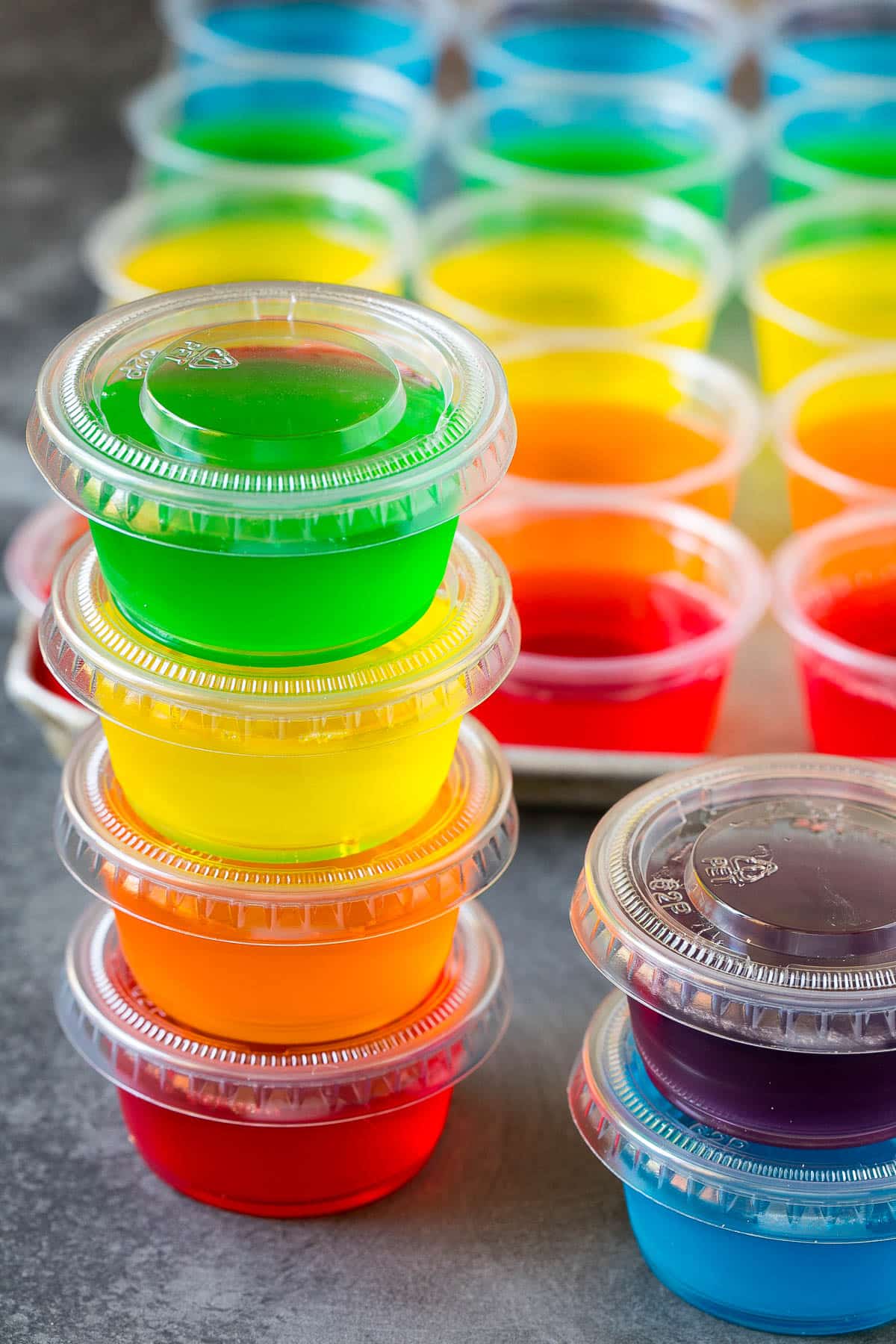A stack of gelatin shots in plastic containers.