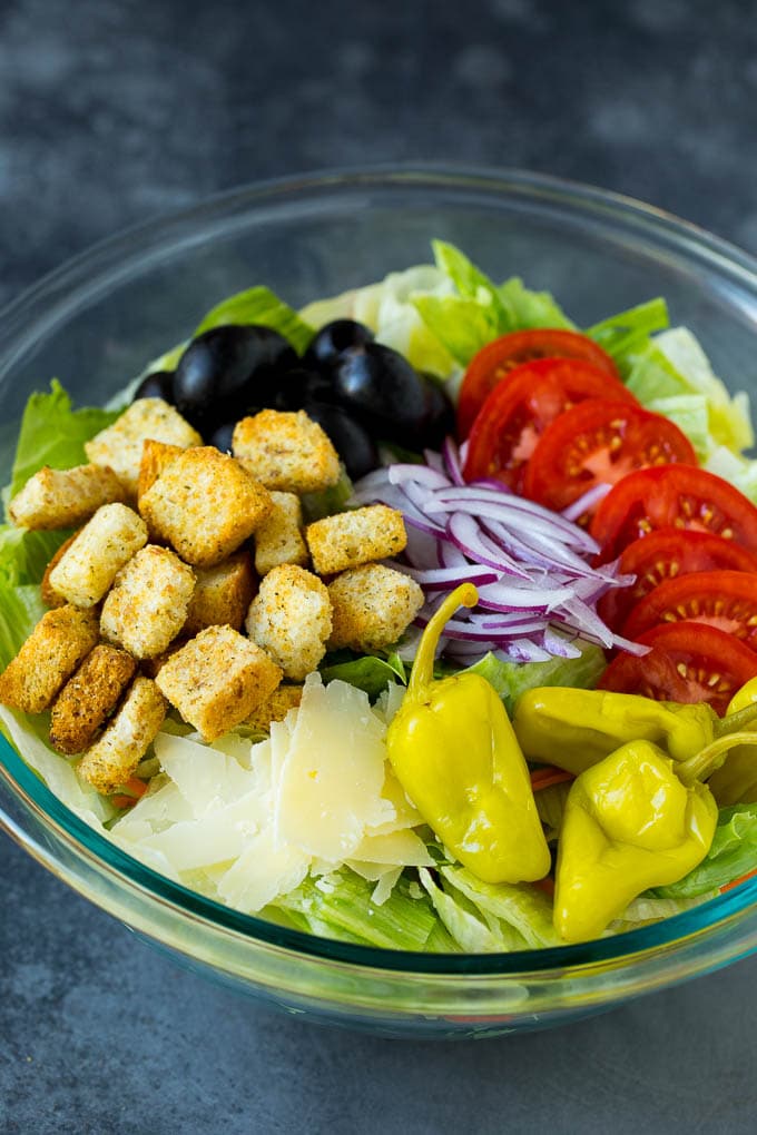 Lettuce, vegetables, olives and croutons in a bowl.