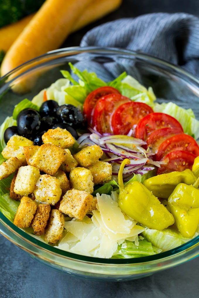 Olive Garden salad with tomatoes, croutons, cheese and olives.
