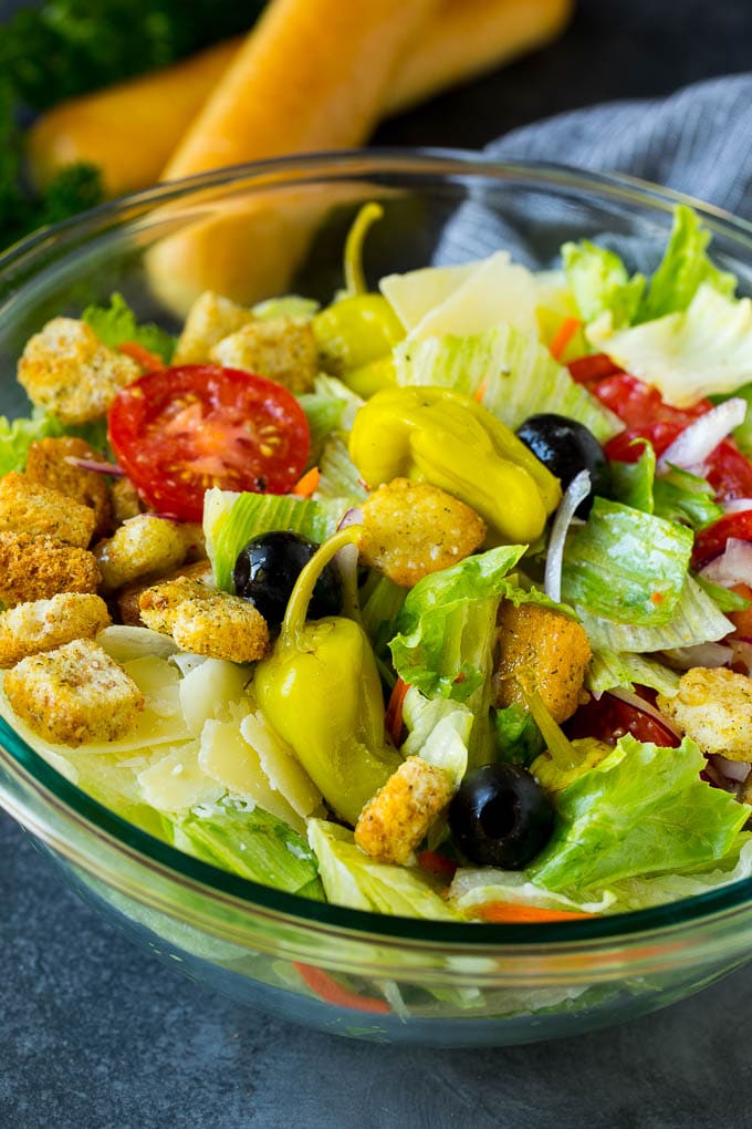 A tossed Olive Garden salad with Italian dressing, vegetables and olives.