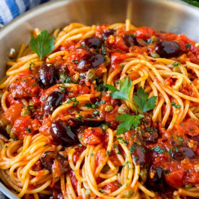 Pasta puttanesca with olives and capers in tomato sauce.