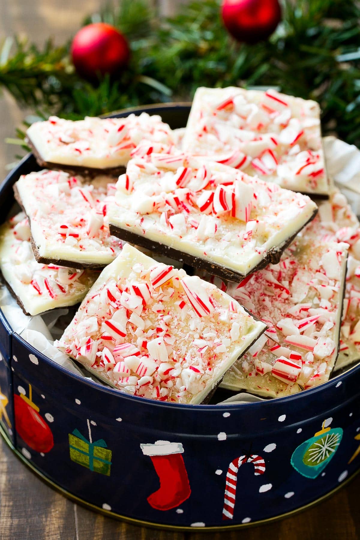 Pieces of peppermint bark in a holiday tin.