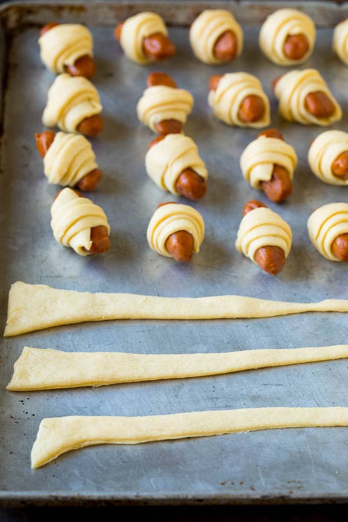 Strips of crescent dough on a sheet pan.