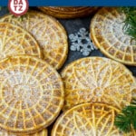 This pizzelle recipe is flat crispy vanilla flavored cookies that are baked in an iron, then finished with a dusting of powdered sugar.