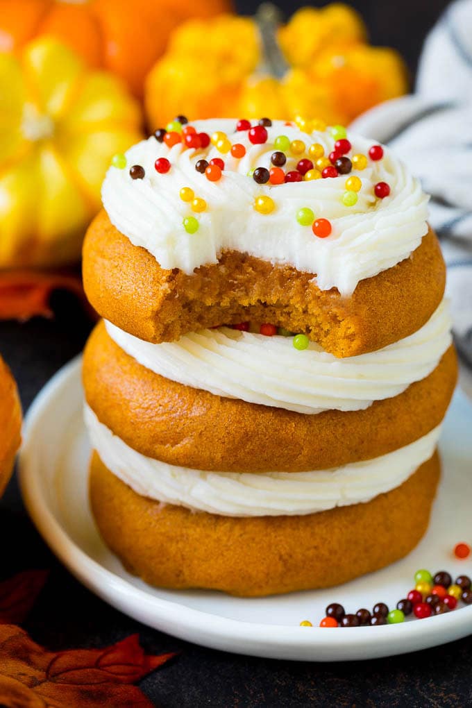 A stack of pumpkin cookies with a bite taken out of one.