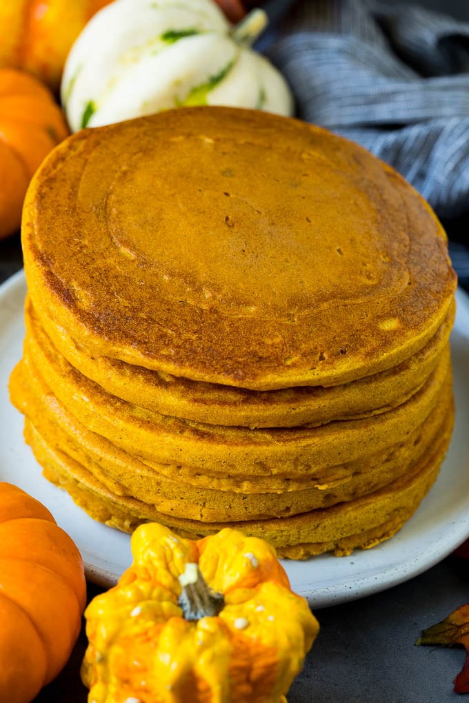 A stack of pancakes surrounded by fall decorations.