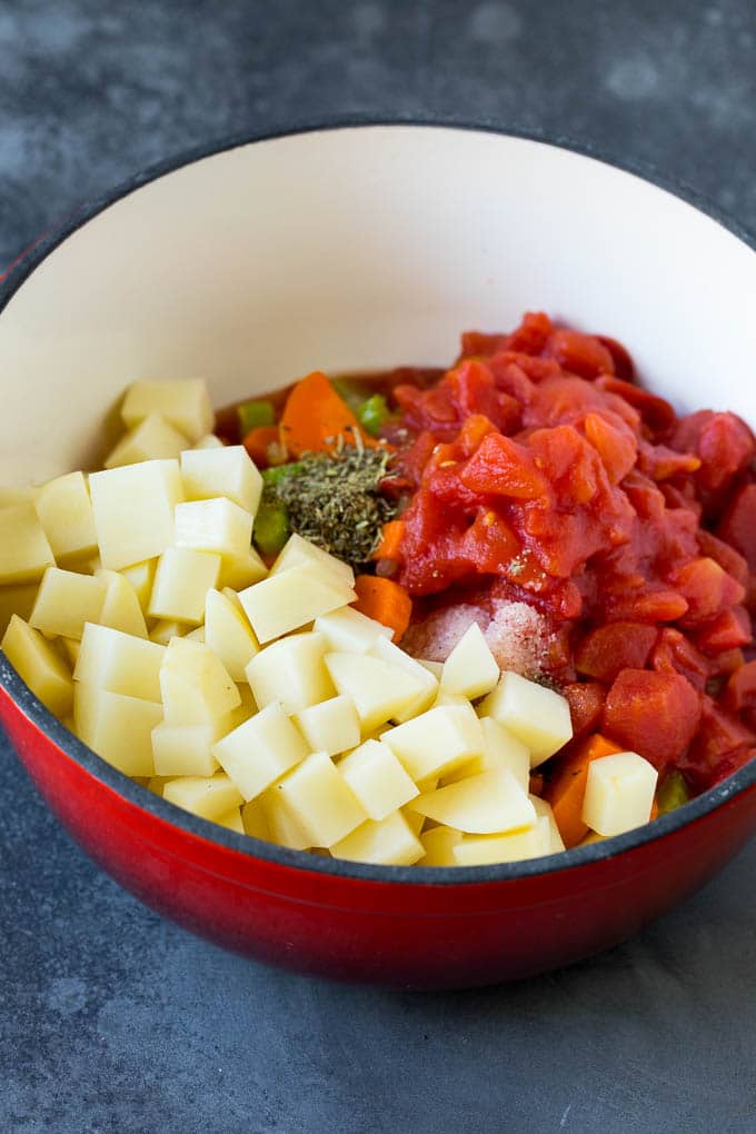 Vegetables, diced potatoes and tomatoes in a pot.