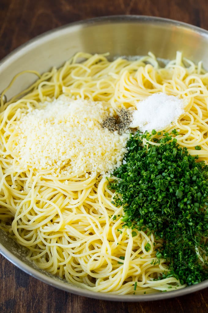 Pasta topped with herbs, cheese, salt and pepper.