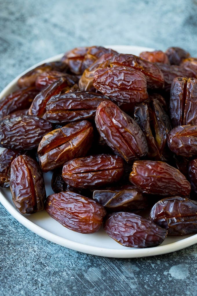 Dates split open on a plate.