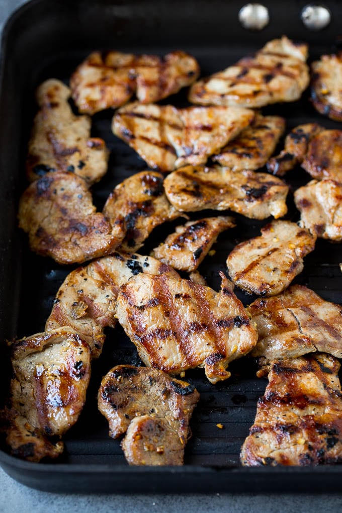 Thinly sliced pork on a grill pan.