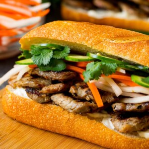 A bahn mi sandwich layered with pork, pickled vegetables and herbs.