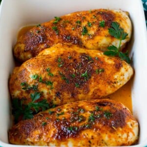 Baked chicken breast topped with fresh chopped parsley.