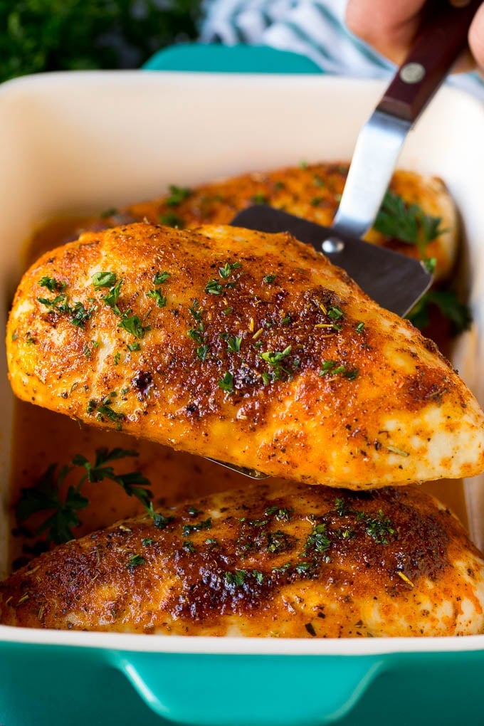 A spatula serving up a portion of roasted chicken breast.