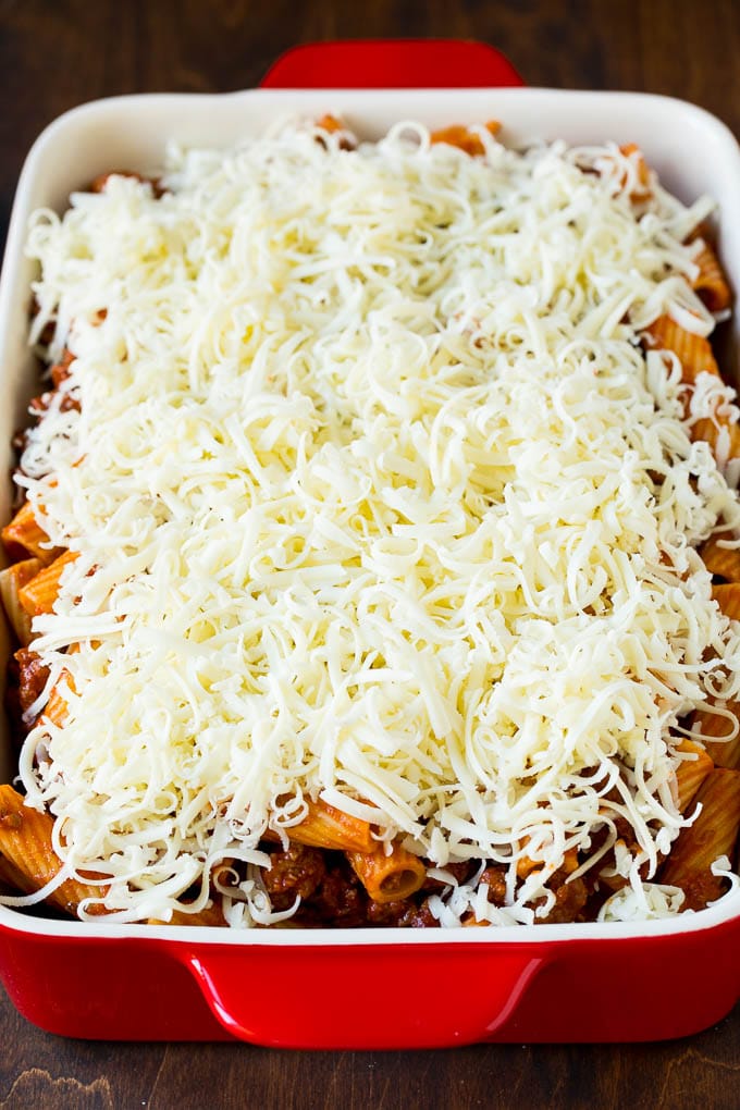 Baked Rigatoni Pasta #pasta #dinner #italianfood #groundbeef #dinneratthezoo #casserole A pan of pasta in sauce topped with shredded cheese.