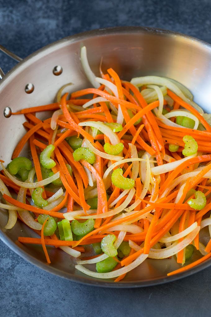 Cooked carrots, onions and celery in a skillet.