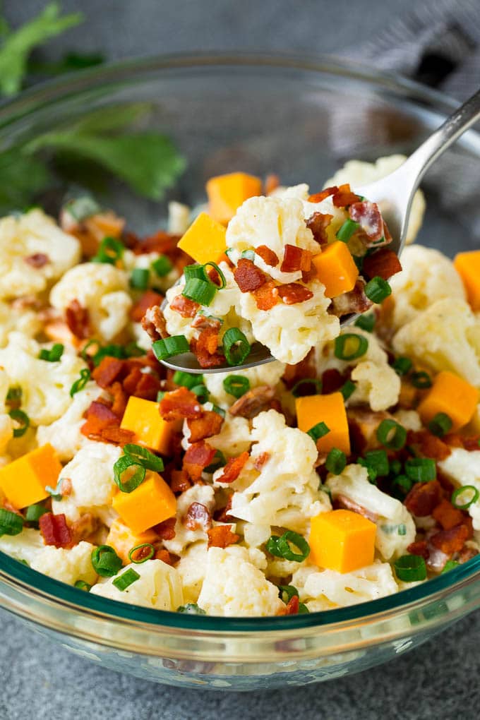 A spoon serving up a portion of cauliflower salad.