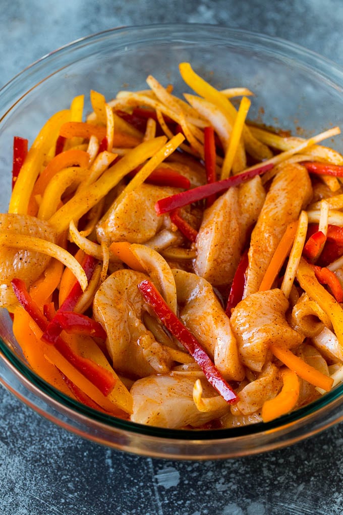 Sliced chicken and vegetables coated in fajita marinade.