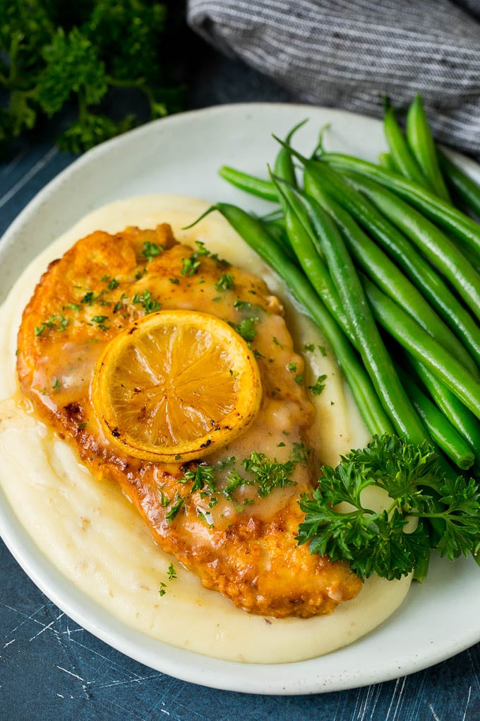 Chicken francese served over mashed potatoes with green beans.