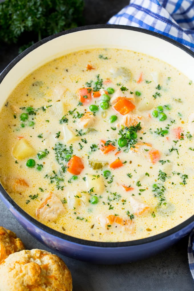 Creamy chicken pot pie soup served with biscuits on the side.
