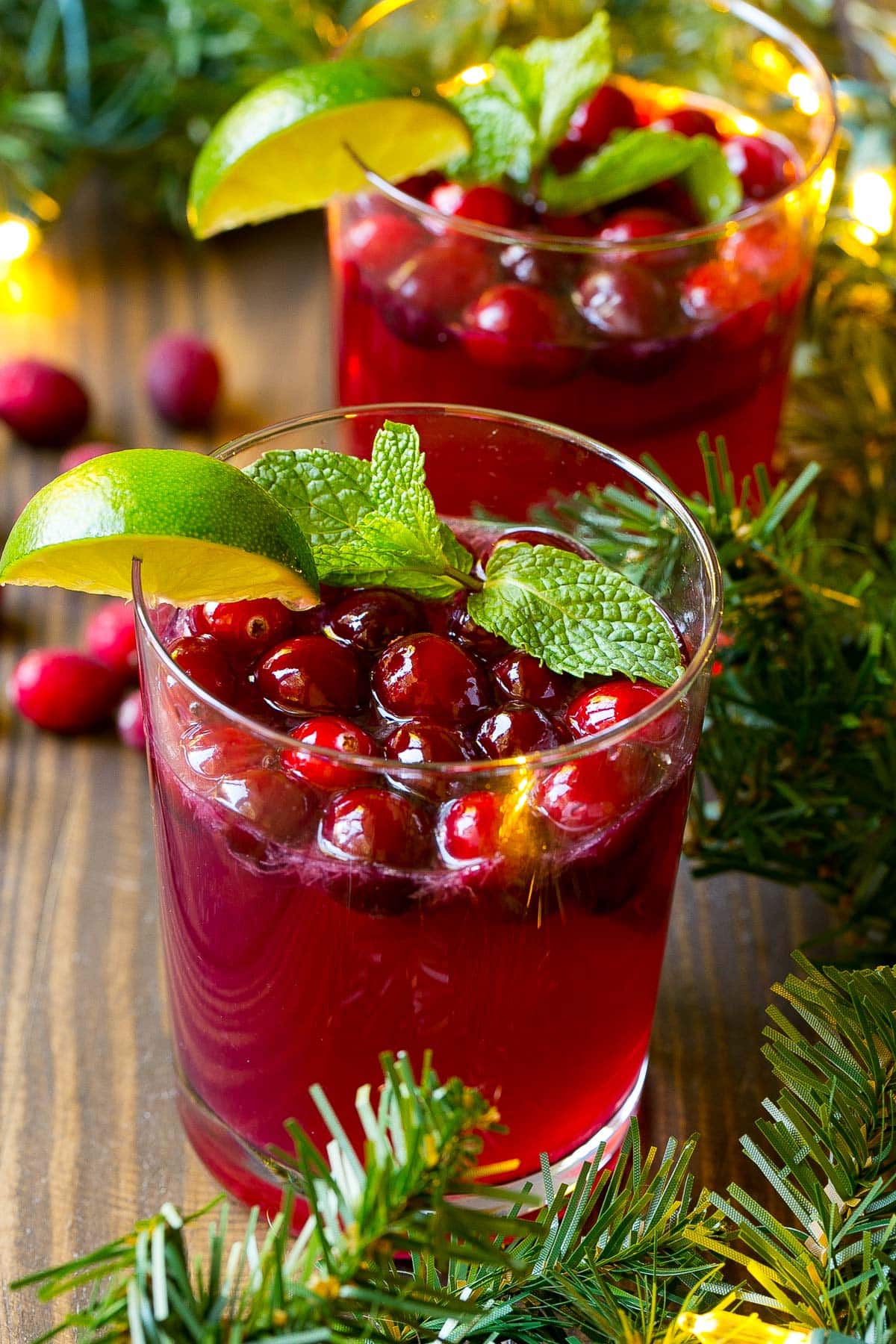 Cups of Christmas punch topped with cranberries, lime and mint.