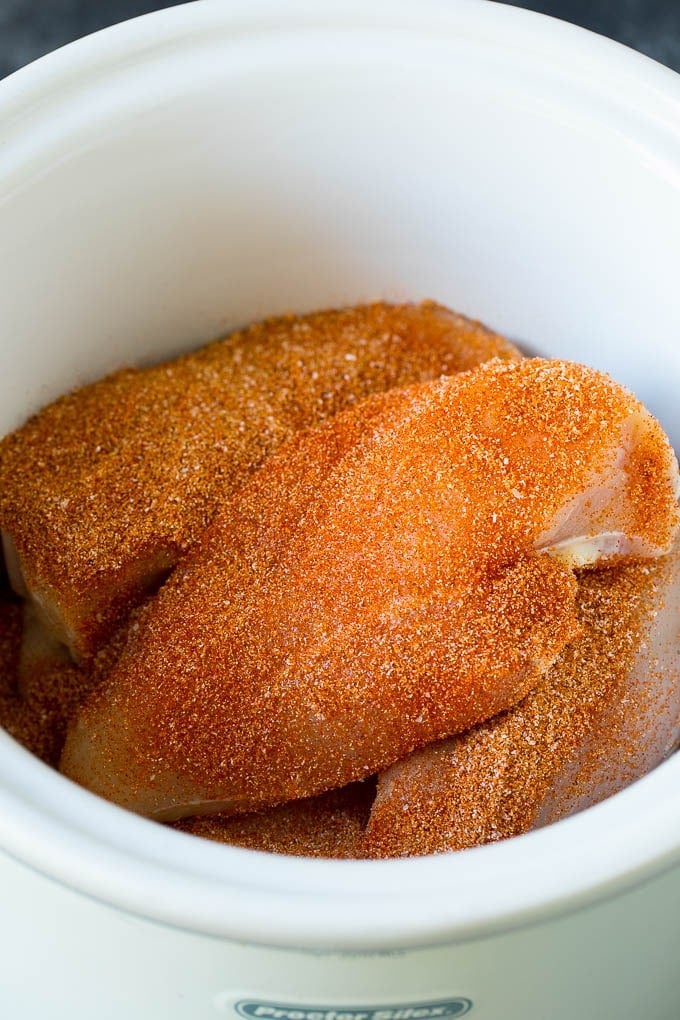 Chicken breasts coated in spice rub in a crockpot.