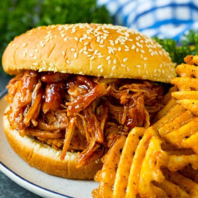 Crockpot BBQ chicken on a bun served with french fries.