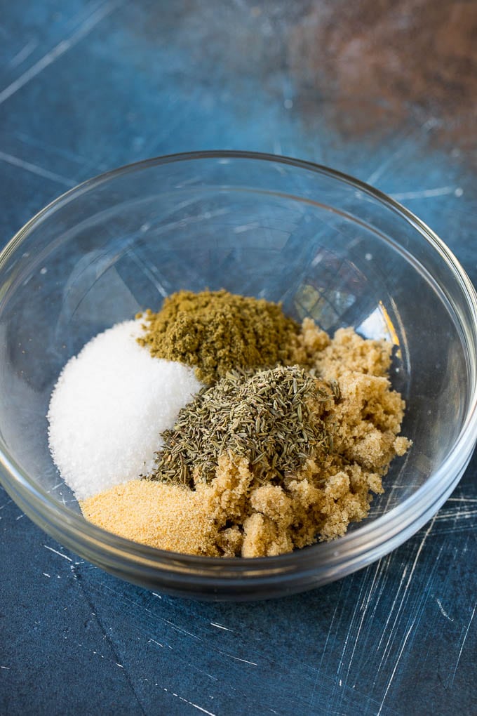 Brown sugar, salt and herbs in a mixing bowl.