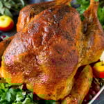 A dry brined turkey garnished with fresh herbs and cranberries.