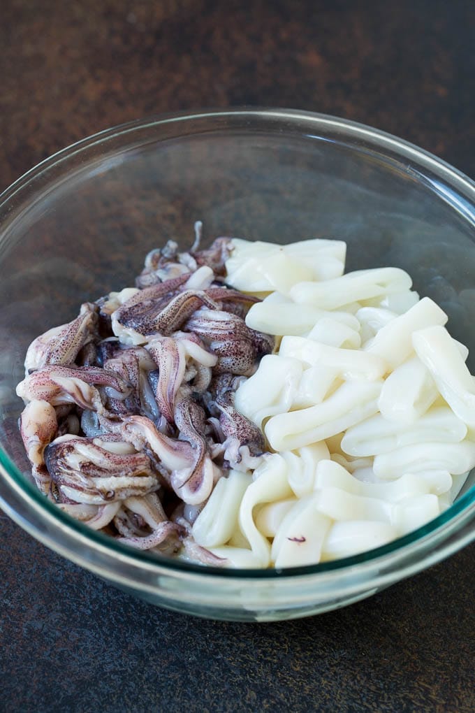 Sliced squid rings and tentacles in a mixing bowl.