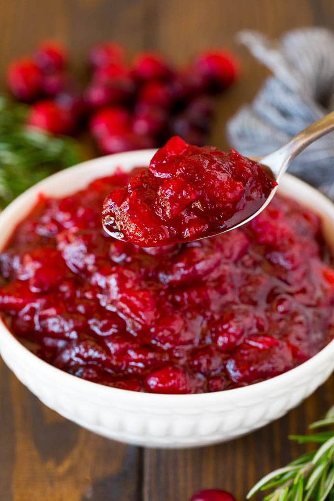 A spoon holding up a portion of homemade cranberry sauce.
