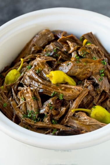 A slow cooker filled with shredded Mississippi pot roast.