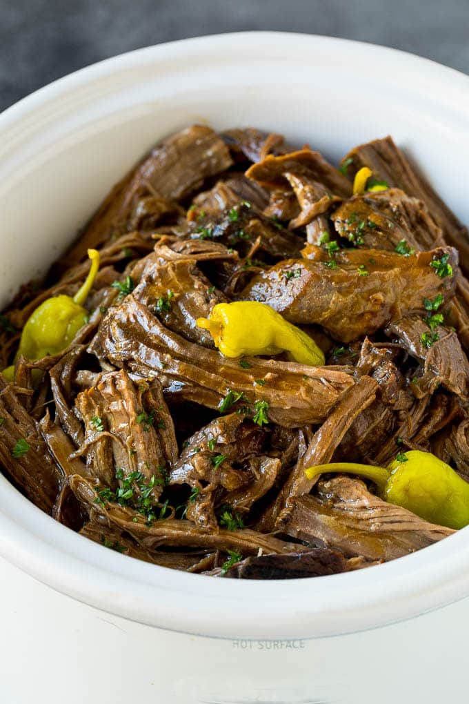 A slow cooker filled with shredded Mississippi pot roast.